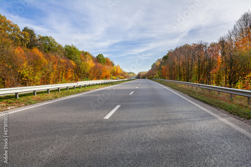 Highway among the autumn forest. Beautiful autumn landscape