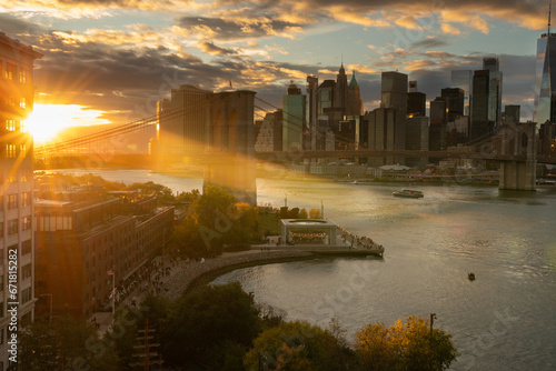 Amazing dramatic sunset over Manhattan skyline featuring Brooklyn Bridge over East River in October
