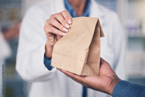 Woman, pharmacist and hands with paper bag for patient, healthcare or medication at the pharmacy. Closeup of female person or medical professional giving pills, drugs or pharmaceuticals to customer