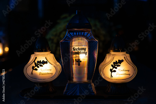 Candle light in the cemetery at night. Selective focus.All saint's day.  Lanterns in the cemetery at night.Lantern on the background of burning candles in the night. photo