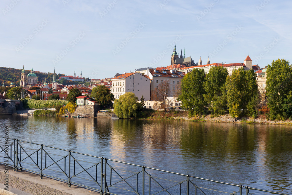 Autumn colorful Prague Lesser Town with gothic Castle above River Vltava in the sunny Day, Czech Republic