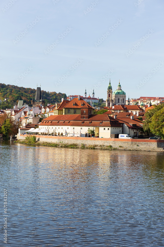 Autumn colorful Prague Lesser Town with gothic Castle above River Vltava in the sunny Day, Czech Republic