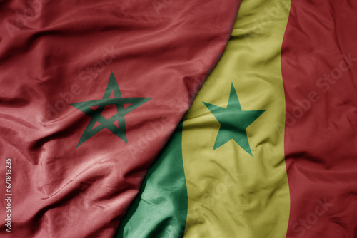 big waving national colorful flag of morocco and national flag of senegal .
