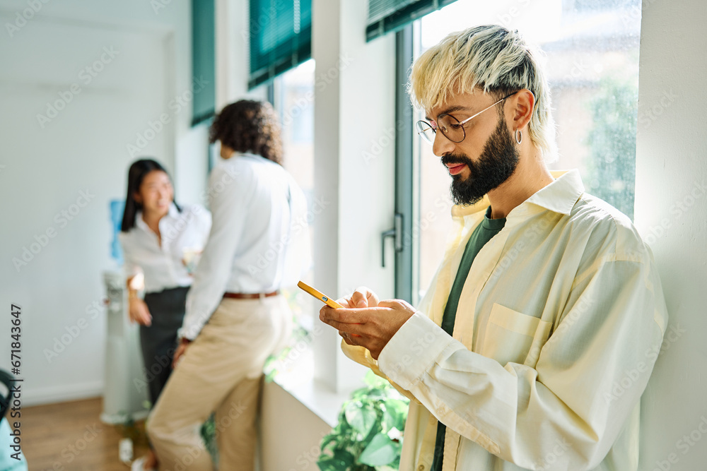 Fototapeta premium Distracted young man using phone in a coworking