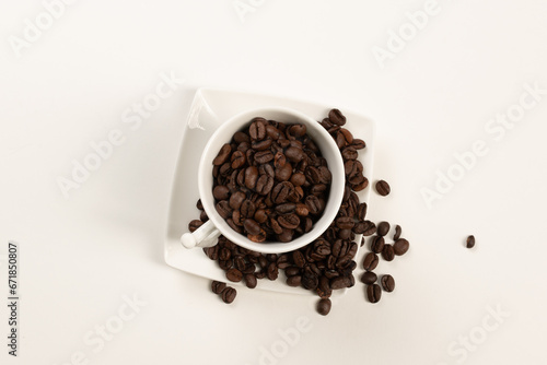 white cup with coffee beans on white and black background