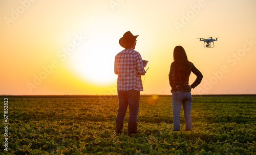 Farmers driving drone above field