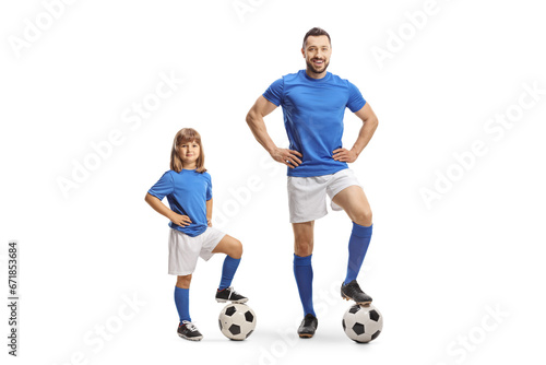 Girl in sports jersey standing with foot on top of a football next to a footballer