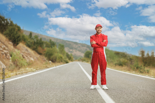 Racer in a red suit standing on the road