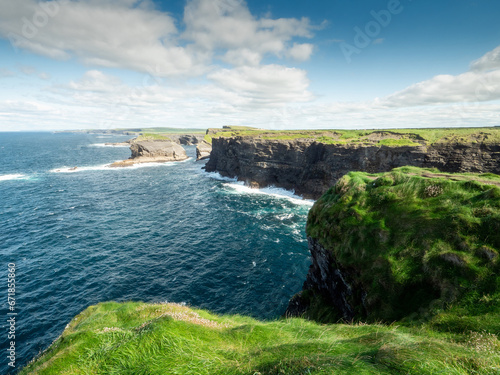 Stunning nature scene with cliffs  Atlantic ocean and low cloudy sky on sunny day. Kilkee area  Ireland. Travel  tourism and sightseeing concept. Irish landscape and coastline.