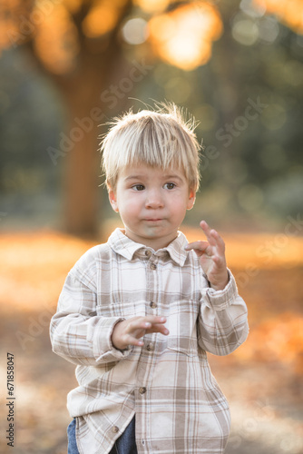 Autumn portrait of 2-3 years old child in garden. Fall season. Close-up view of cheerful sweet baby boy