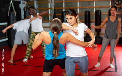 Two woman is training on the self defense course in gym