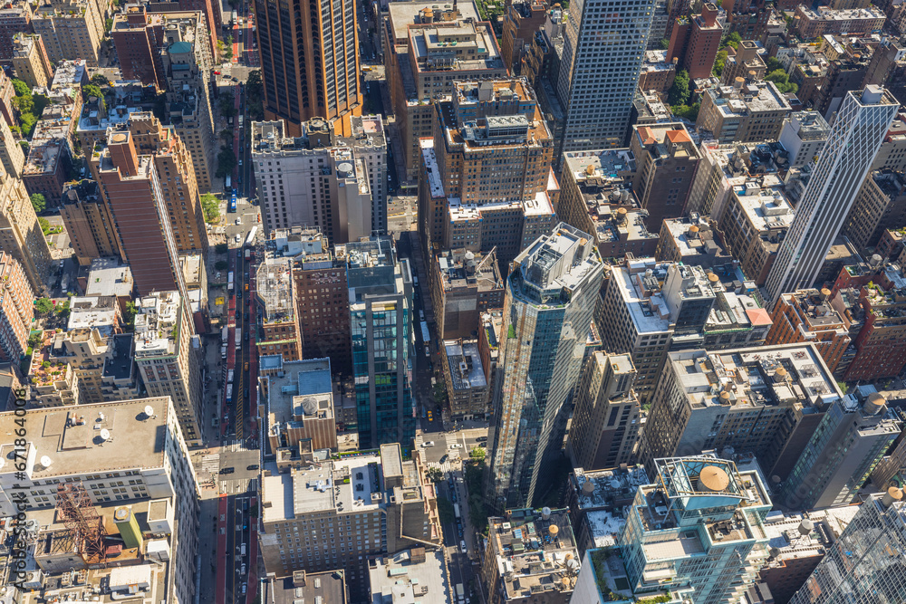 Fototapeta premium Aerial view from Empire State Building of rooftops of skyscrapers and bustling 34th Street in Manhattan, with transportation visible below. New York, USA.