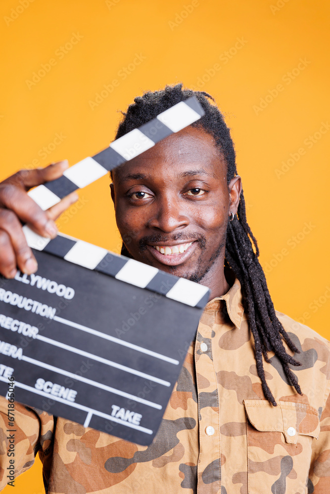 Portrait of producer holding clapperboard to cut scenes in movie making