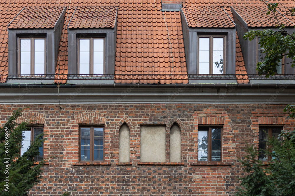 Detail of the facade of an old brick house with windows.
