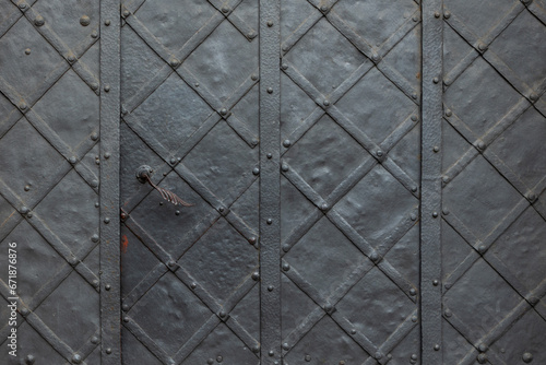 Old metal door with forged elements and lock, close-up.