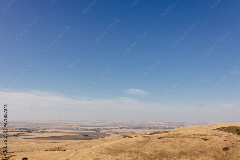 Fototapeta premium Beautiful autumn landscape with meadows and a road from a bird's eye view. Nature in Oregon in fall. Panorama. Pendleton, Oregon, USA