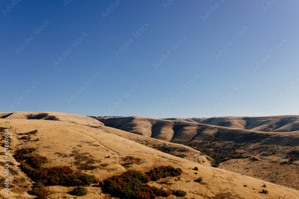 Naklejka premium Beautiful autumn landscape with meadows and a road from a bird's eye view. Nature in Oregon in fall. Panorama. Pendleton, Oregon, USA