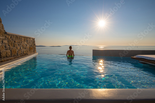 Tourist enjoys at the infinity swimming pool villa at Mykonos, Greece © Kyrenian