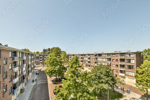 Fototapeta Naklejka Na Ścianę i Meble -  an apartment complex with trees and cars parked in the parking lot, taken from above on a clear blue sky day