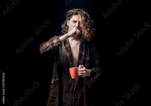 Mans holds cup of coffee and yawning. Morning tea. Yawning face. Man with tea cup. Hipster man yawning with cup of coffee. Bearded man yawning hold mug tea. Wake up. Happy day. After morning tea.