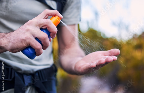 Sunscreen spray, hand and closeup while hiking for security from the sun and health in summer. Exercise, nature and a man with a bottle with cream for skincare and safety from sunshine for fitness