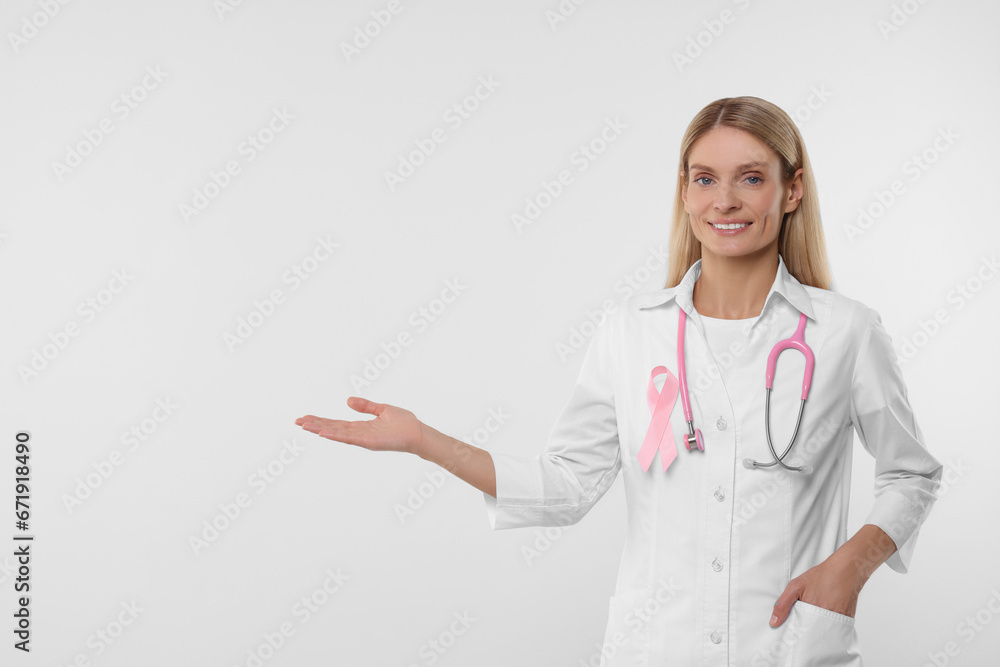 Doctor with pink ribbon and stethoscope on white background, space for text. Breast cancer awareness Doctor with pink ribbon and stethoscope on white background, space for text. Breast cancer awareness