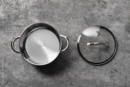 Empty steel pot and lid on grey table, flat lay