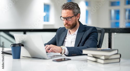 Modern office. Successful caucasian business man in business suit using laptop, working remotely, e-commerce online at office. Finance auditor. Ceo manager employee having business idea. Business