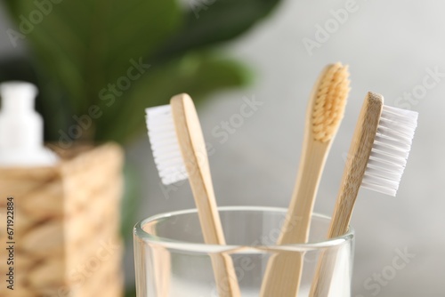 Bamboo toothbrushes in holder on blurred background  closeup