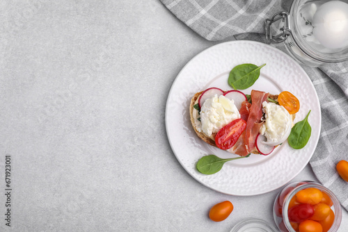 Delicious sandwich with burrata cheese  ham  radish and tomatoes served on light grey table  flat lay. Space for text