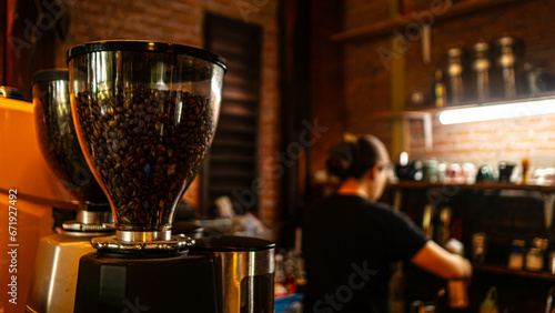 Fresh coffee beans in a glass jar on a coffee shop counter.