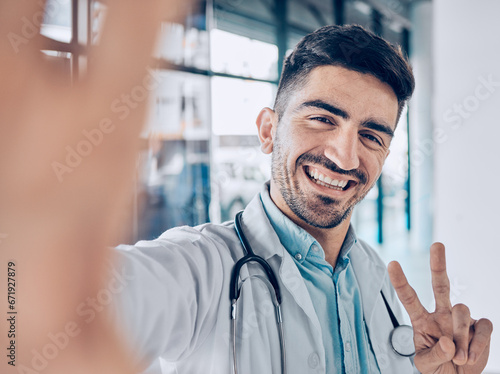 Happy, selfie and man doctor peace sign for social media for healthcare, medical and hospital work. Job, male professional and surgeon worker portrait with picture and smile for internet photo