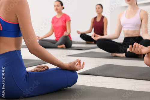Group of people practicing yoga on mats indoors, closeup
