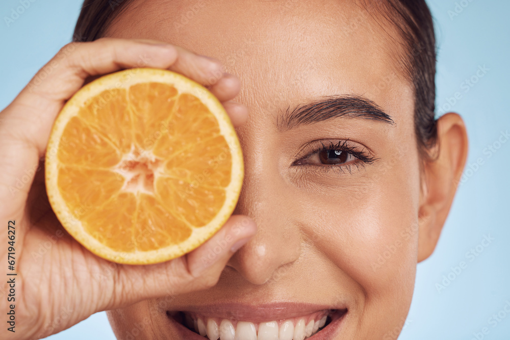 Closeup woman, portrait and orange for vitamin C, diet or skincare against a blue studio background. Face of happy person smile with organic citrus fruit in natural nutrition, spa or facial treatment Closeup woman, portrait and orange for vitamin C, diet or skincare against a blue studio background. Face of happy person smile with organic citrus fruit in natural nutrition, spa or facial treatment