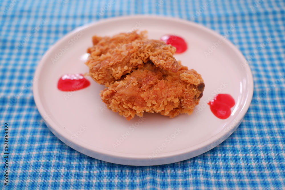 Crispy fried chicken on a plate with sauce, stock photo