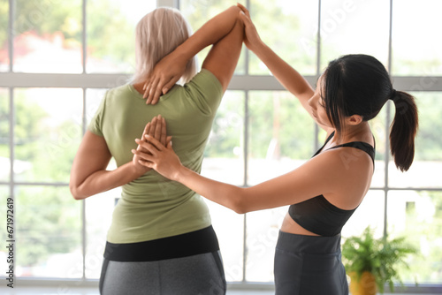 Female yoga instructor assi...