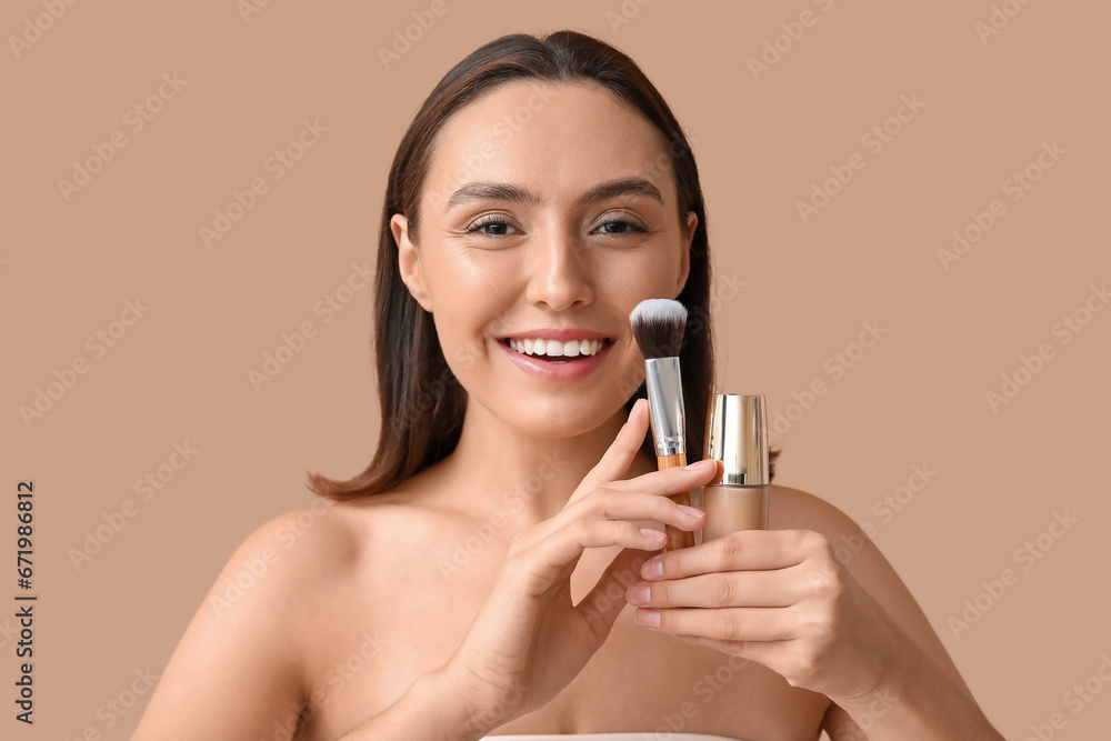Young woman with makeup foundation and brush on beige background, closeup Young woman with makeup foundation and brush on beige background, closeup