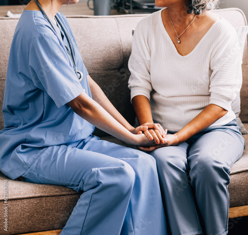 Happy senior woman visiting doctor, getting optimistic news after medical checkup, therapy. Therapist holding hand of old patient, giving hope, support, congratulating on goor treatment result