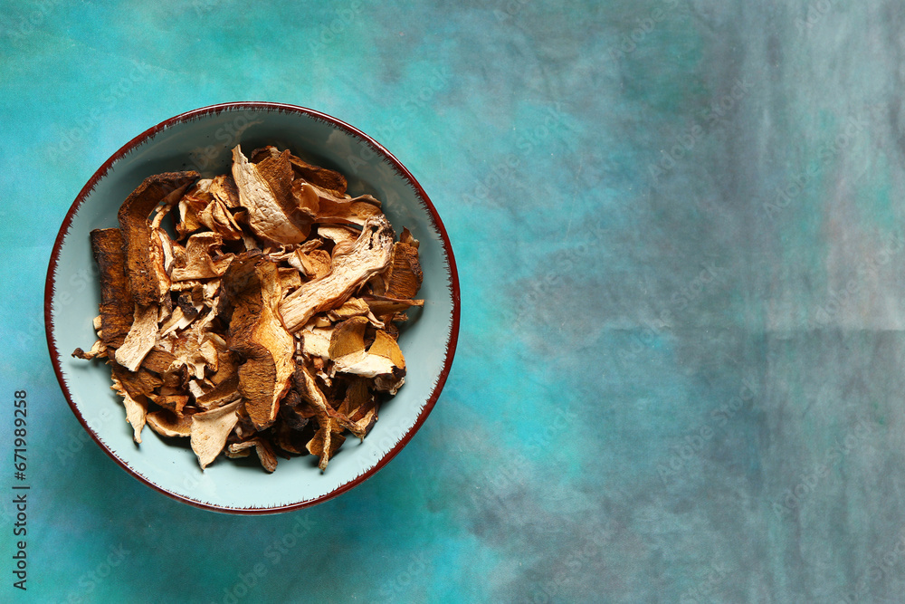 Bowl with tasty dried mushrooms on blue background Bowl with tasty dried mushrooms on blue background