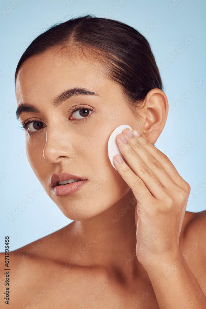 Woman, face and cotton pad for skincare or makeup removal against a blue studio background. Portrait of female person with swab for cleaning foundation, beauty cosmetics or facial skin treatment Woman, face and cotton pad for skincare or makeup removal against a blue studio background. Portrait of female person with swab for cleaning foundation, beauty cosmetics or facial skin treatment