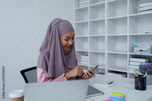 Muslim female employee Using the phone to talk to customers in the office.