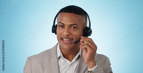 Call center, man and portrait in studio for customer service, CRM questions and IT support on blue background. Face of telemarketing salesman, virtual consultant and microphone for telecom advisory