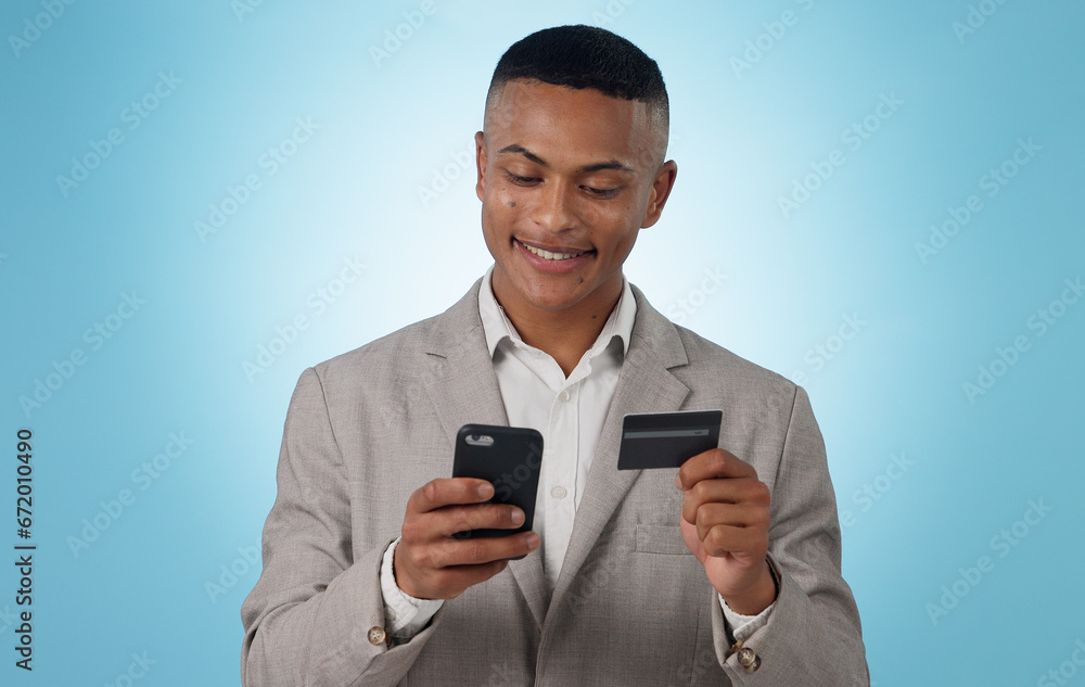 Business man, credit card and phone in studio for ecommerce, financial accounting or banking investment on blue background. Happy worker, mobile and fintech for online shopping, stock trading or deal Business man, credit card and phone in studio for ecommerce, financial accounting or banking investment on blue background. Happy worker, mobile and fintech for online shopping, stock trading or deal