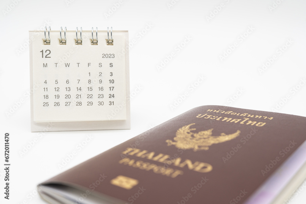 Simple desk calendar for December 2023 and Passport. Calendar and holiday concept with passport isolate on white background. Simple desk calendar for December 2023 and Passport. Calendar and holiday concept with passport isolate on white background.