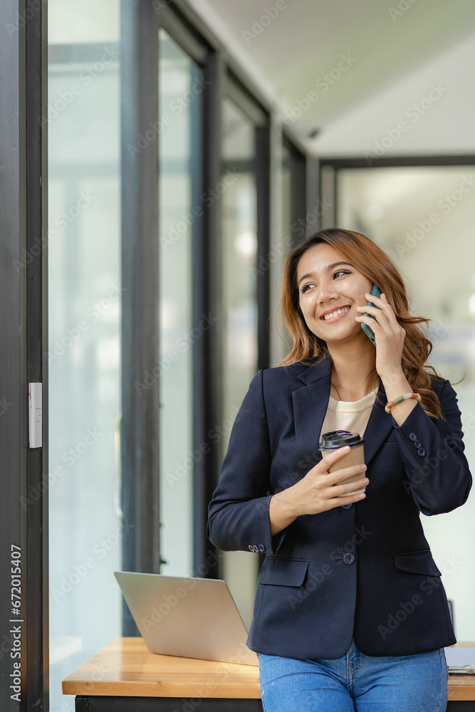 Happy young woman calling her friend speak and ask about something using laptop Businesswoman working at laptop while sitting at table at home and talking on phone. Freelance. Working from home. Happy young woman calling her friend speak and ask about something using laptop Businesswoman working at laptop while sitting at table at home and talking on phone. Freelance. Working from home.