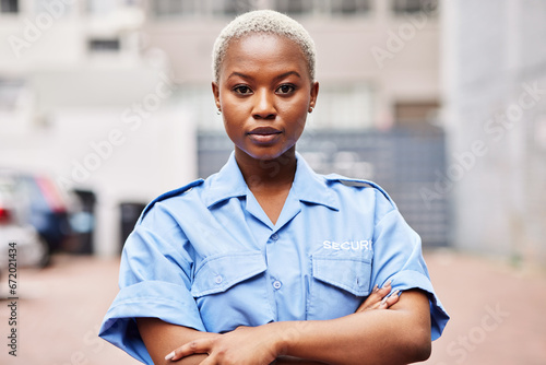 Portrait, black woman and security guard with arms crossed for surveillance service, safety and urban watch. Law enforcement, bodyguard or serious female police officer in blue shirt for city patrol
