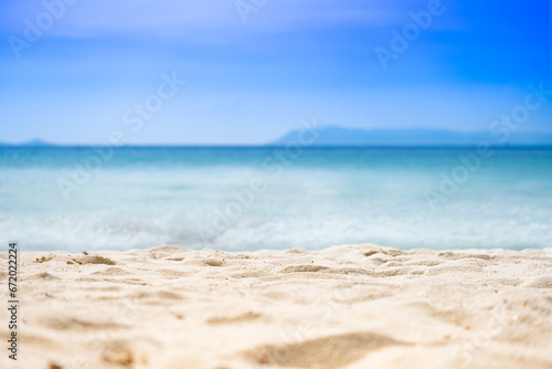 Fototapeta Naklejka Na Ścianę i Meble -  Beach sand background for summer vacation concept. Beach nature and summer seawater with sunlight light sandy beach Sparkling sea water contrast with the blue sky	
