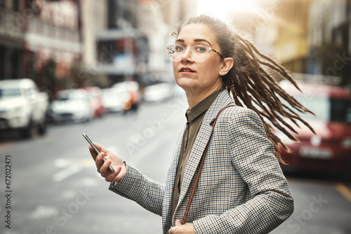 Phone, portrait and business woman in city for social media, email and typing at sunset commute. Mobile, consultant and serious face of professional from Switzerland with glasses in street for travel