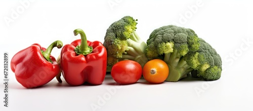 Choose to concentrate on a variety of vegetables specifically capsicum and broccoli which are separated from the rest and placed on a white background table