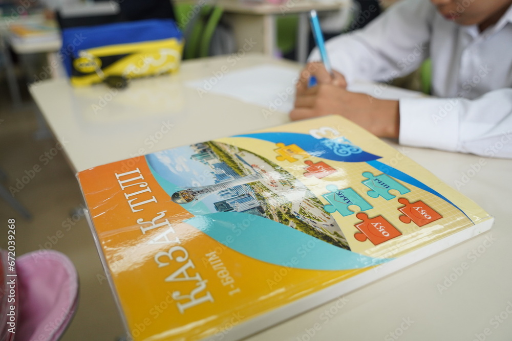 Almaty, Kazakhstan - 09.06.2023 : A textbook on the Kazakh language on the student's desk.